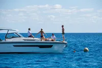 People enjoying a day on a 2022 Nimbus T11 boat in clear blue waters.