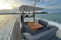 Nimbus T11 2x350 boat cruising on open water, featuring spacious seating and a wooden table.
