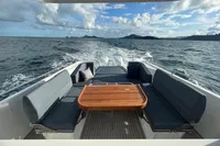 Luxury Nimbus T11 boat with sleek seating and wooden table cruising on open water.