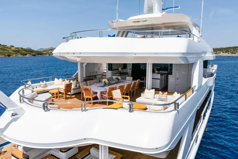 Fortuna Yacht Photos Pics Luxurious 2022 CMB Yachts CMB 47 with elegant outdoor dining area on serene blue waters.