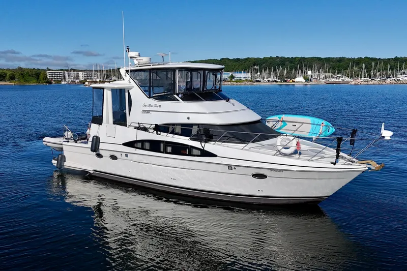 One Last Time II Yacht Photos Pics 2004 Carver 444 Cockpit Motor Yacht on calm water, with marina in background.