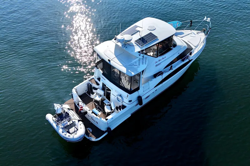 One Last Time II Yacht Photos Pics 2004 Carver 444 Cockpit Motor Yacht on calm water, reflecting sunlight.