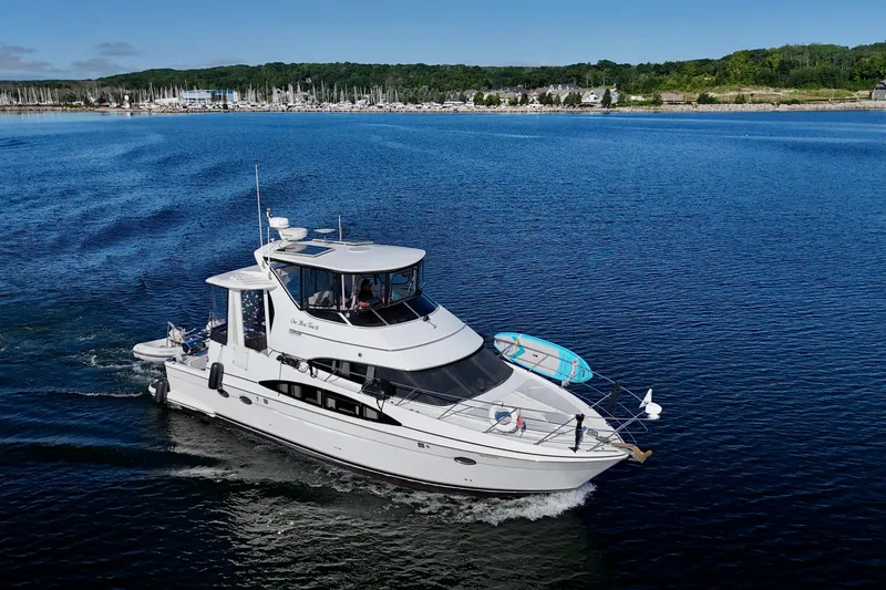 One Last Time II Yacht Photos Pics 2004 Carver 444 Cockpit Motor Yacht cruising on a serene blue lake.