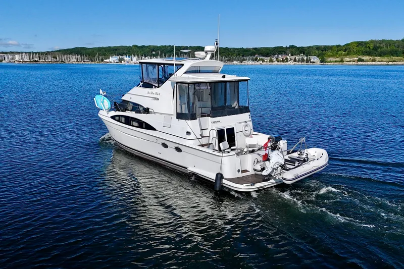 One Last Time II Yacht Photos Pics 2004 Carver 444 Cockpit Motor Yacht cruising on a serene blue lake.