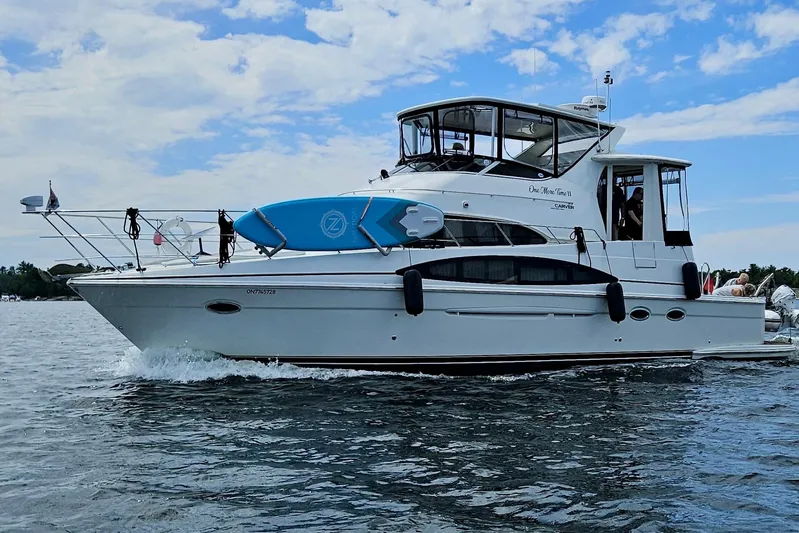 One Last Time II Yacht Photos Pics 2004 Carver 444 Cockpit Motor Yacht cruising on a sunny day with a paddleboard.