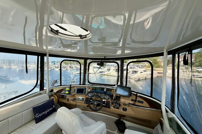 One Last Time II Yacht Photos Pics Interior view of 2004 Carver 444 Cockpit Motor Yacht helm with marina backdrop.