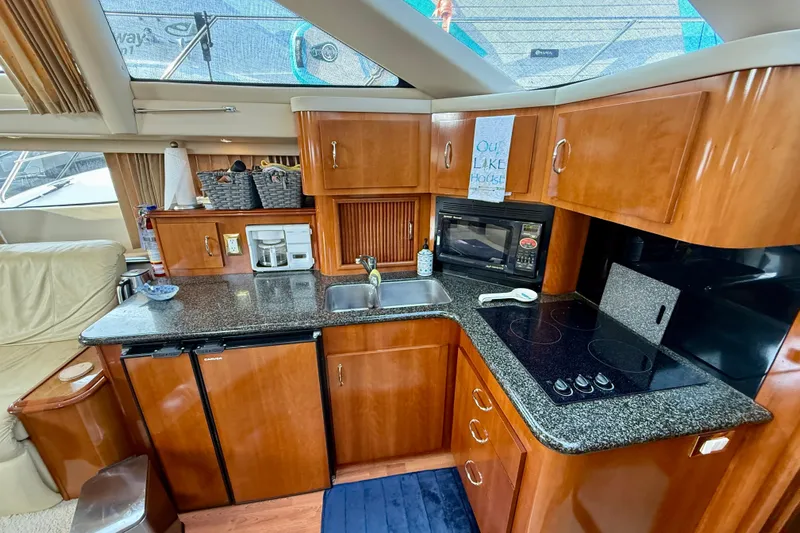 One Last Time II Yacht Photos Pics Luxurious 2004 Carver 444 Cockpit Motor Yacht kitchen with modern amenities and wood cabinetry.