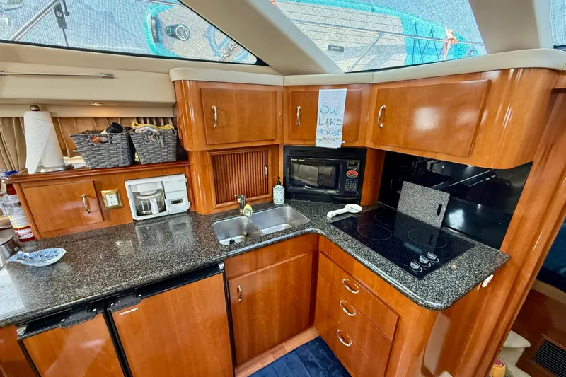One Last Time II Yacht Photos Pics 2004 Carver 444 Cockpit Motor Yacht kitchen with wood cabinets, granite countertops, and modern appliances.