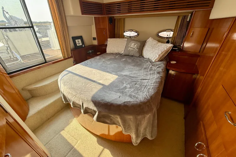 One Last Time II Yacht Photos Pics Luxurious bedroom in 2004 Carver 444 Cockpit Motor Yacht with cozy bed and elegant wood finish.