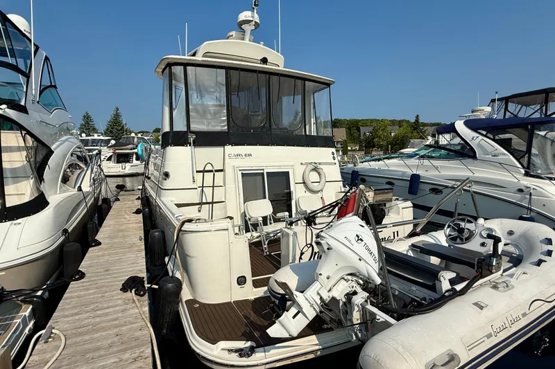 One Last Time II Yacht Photos Pics 2004 Carver 444 Cockpit Motor Yacht docked with inflatable boat, surrounded by other yachts.