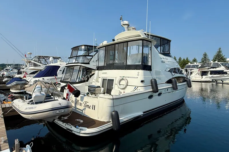 One Last Time II Yacht Photos Pics 2004 Carver 444 Cockpit Motor Yacht docked in a marina, surrounded by other boats.