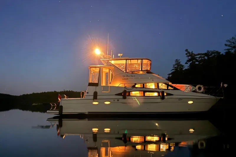 One Last Time II Yacht Photos Pics 2004 Carver 444 Cockpit Motor Yacht illuminated at night on calm water.