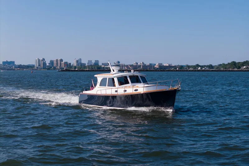 Ingrid Yacht Photos Pics 2007 Gorbon Custom Downeast 40 cruising on water with city skyline in background.