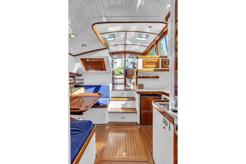 Ingrid Yacht Photos Pics Interior of 2007 Gorbon Custom Downeast 40 yacht with wood accents and blue seating.