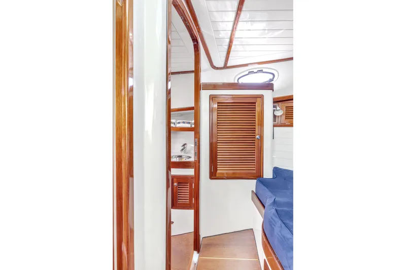 Ingrid Yacht Photos Pics Interior of 2007 Gorbon Custom Downeast 40 yacht with wooden finishes and blue seating.