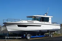 2024 Nimbus Commuter 11 boat on trailer, sleek design, clear blue sky background.