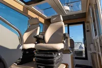 Interior of 2024 Nimbus Commuter 11 with two beige captain chairs and panoramic windows.