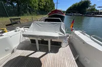 2024 Nimbus Commuter 11 boat docked, featuring spacious deck and covered seating area.