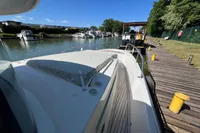 2024 Nimbus Commuter 11 docked at a marina, showcasing sleek design and spacious deck.