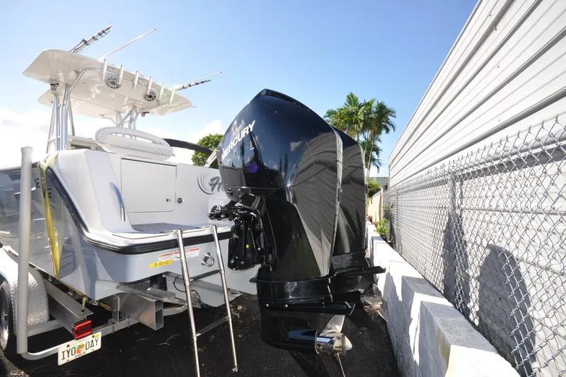  Yacht Photos Pics 2020 SeaVee 290B boat with Mercury outboard motor, parked beside a fence.