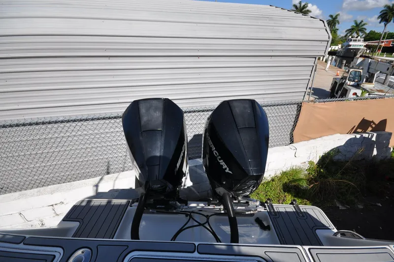  Yacht Photos Pics 2020 SeaVee 290B boat with dual Mercury outboard engines, docked near a fence.