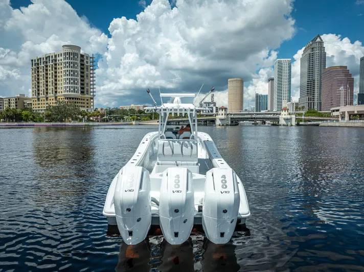  Yacht Photos Pics 2025 Yellowfin 36 boat with triple engines on urban waterfront, city skyline in background.