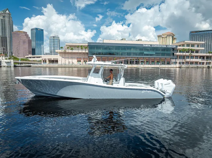  Yacht Photos Pics 2025 Yellowfin 36 boat cruising near Tampa Convention Center, city skyline in background.