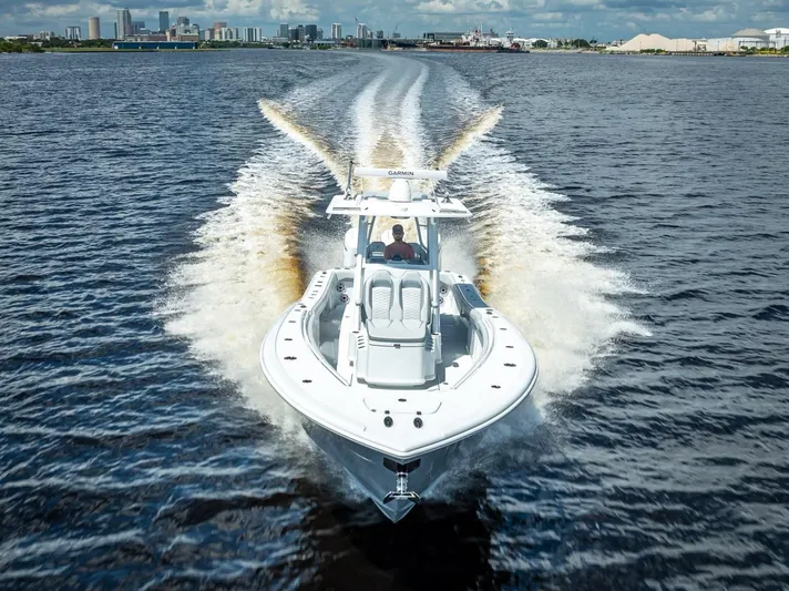  Yacht Photos Pics 2025 Yellowfin 36 boat cruising on open water with city skyline in background.
