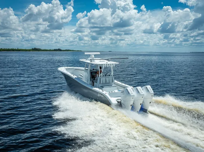  Yacht Photos Pics 2025 Yellowfin 36 boat cruising on open water under a cloudy sky.