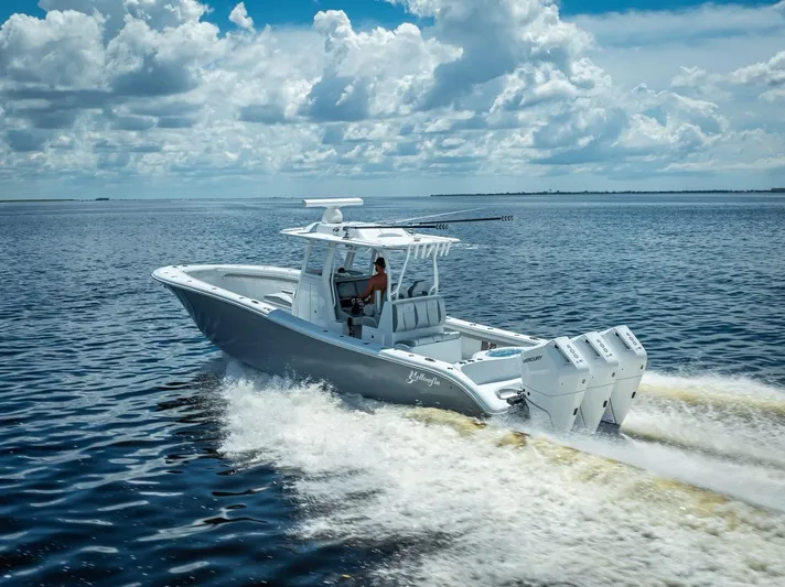  Yacht Photos Pics 2025 Yellowfin 36 boat cruising on open water under a cloudy sky.