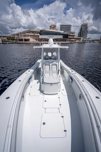  Yacht Photos Pics 2025 Yellowfin 36 boat on water with cityscape background under cloudy sky.