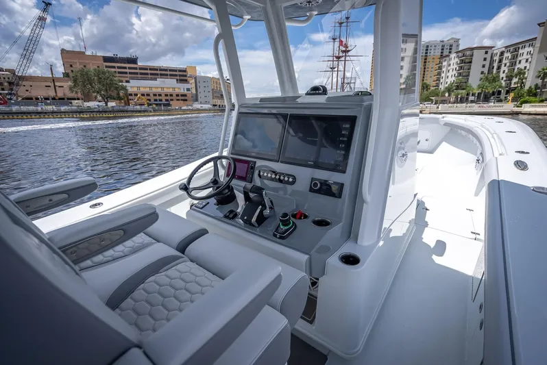  Yacht Photos Pics 2025 Yellowfin 36 boat interior with modern controls, docked in urban marina.