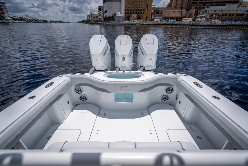  Yacht Photos Pics 2025 Yellowfin 36 boat with triple engines on a calm waterfront.