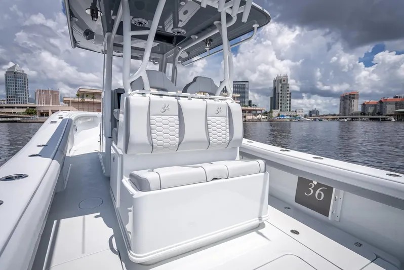  Yacht Photos Pics 2025 Yellowfin 36 boat with sleek design, white seating, and city skyline in the background.