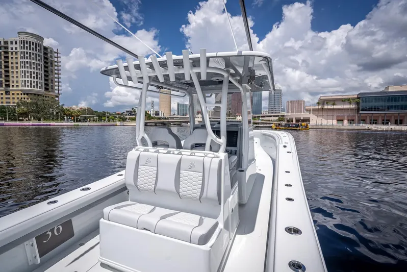  Yacht Photos Pics 2025 Yellowfin 36 boat on water, city skyline in background, clear sky.