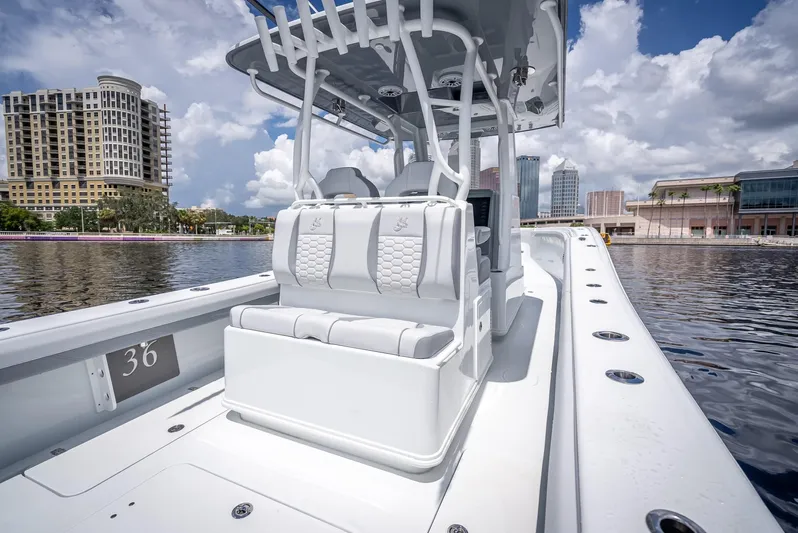  Yacht Photos Pics 2025 Yellowfin 36 boat on water, city skyline in background, clear sky.