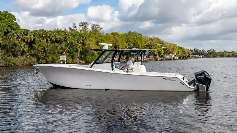 Catahoula Yacht Photos Pics 2023 Front Runner 39 Center Console boat on a calm river with lush greenery.