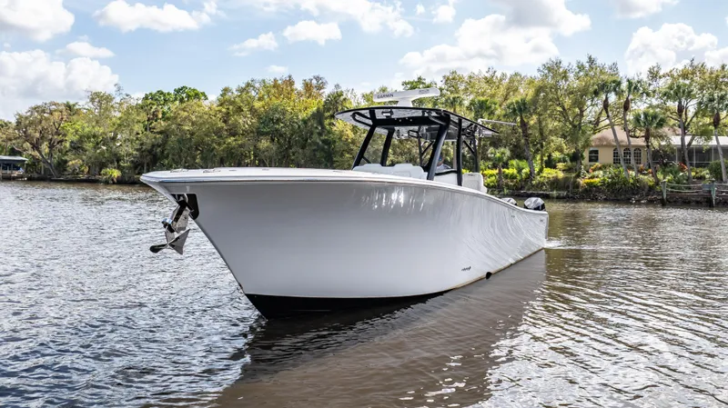 Catahoula Yacht Photos Pics 2023 Front Runner 39 Center Console boat on a calm river with trees in the background.