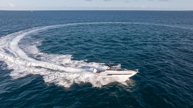  Yacht Photos Pics Aerial view of 2025 Hanover 305 yacht making a circular wake in the ocean.