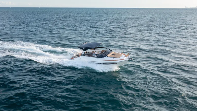  Yacht Photos Pics 2025 Hanover 305 boat cruising on open sea under clear skies.