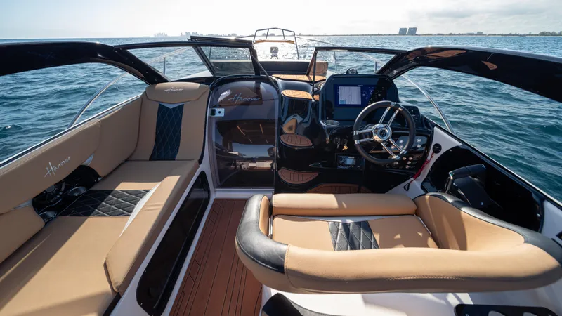  Yacht Photos Pics Luxurious 2025 Hanover 305 boat interior with tan leather seating and modern dashboard on open water.