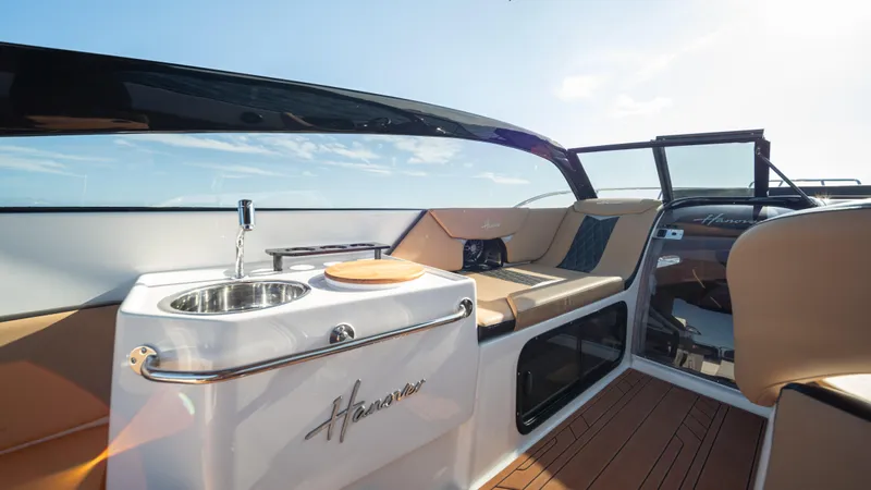  Yacht Photos Pics Luxurious interior of 2025 Hanover 305 boat with seating and kitchenette.