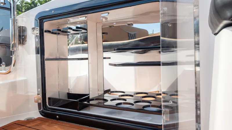  Yacht Photos Pics Open storage compartment on Hanover 305 boat, showcasing shelves and bottle holders, 2026 model.