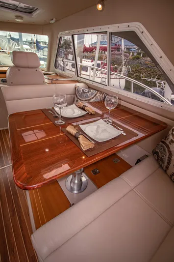 Halcyon Yacht Photos Pics Luxurious interior of 2015 Aspen C100 yacht with elegant dining setup and panoramic windows.