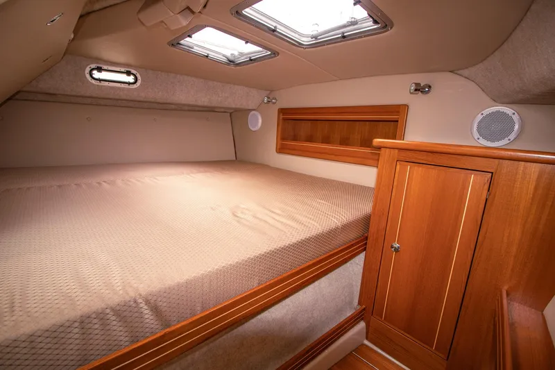 Halcyon Yacht Photos Pics Luxurious cabin interior of 2015 Aspen C100 boat with wooden accents and cozy bedding.