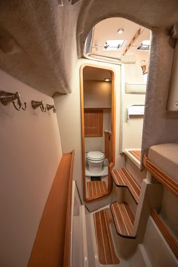 Halcyon Yacht Photos Pics Interior of 2015 Aspen C100 boat featuring a compact bathroom and wooden steps.