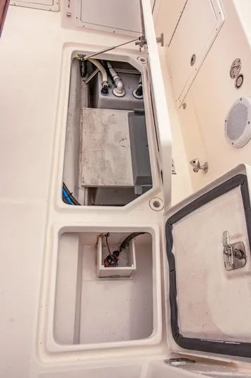 Halcyon Yacht Photos Pics Open storage compartments on a 2015 Aspen C100 boat deck, showing internal wiring and plumbing.
