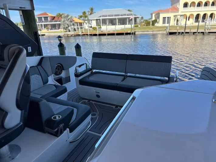  Yacht Photos Pics 2022 Galeon 325 GTO boat interior with seating, docked by waterfront homes.