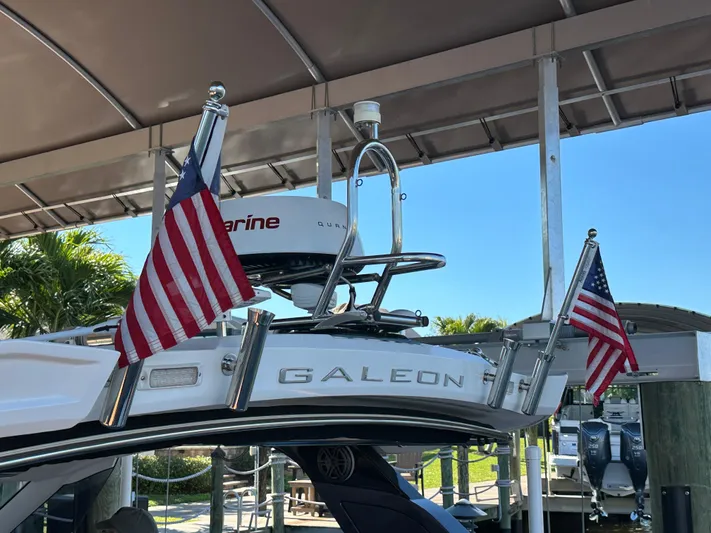  Yacht Photos Pics 2022 Galeon 325 GTO yacht with American flags, docked under a canopy.