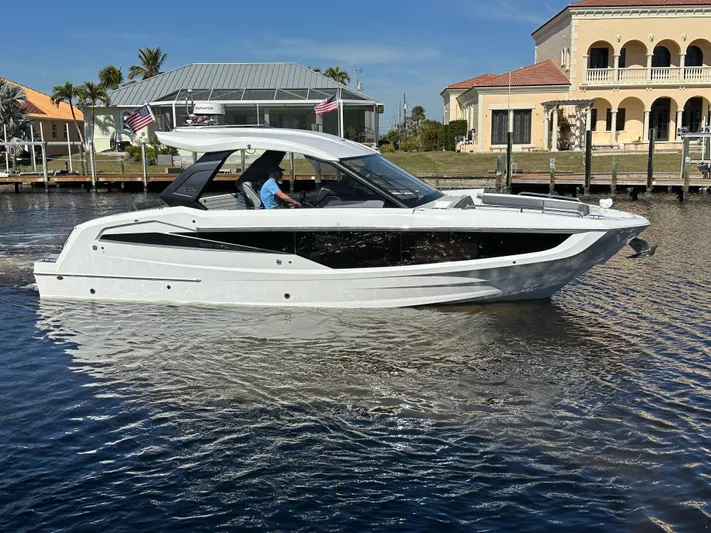  Yacht Photos Pics 2022 Galeon 325 GTO luxury yacht cruising on a sunny waterfront.